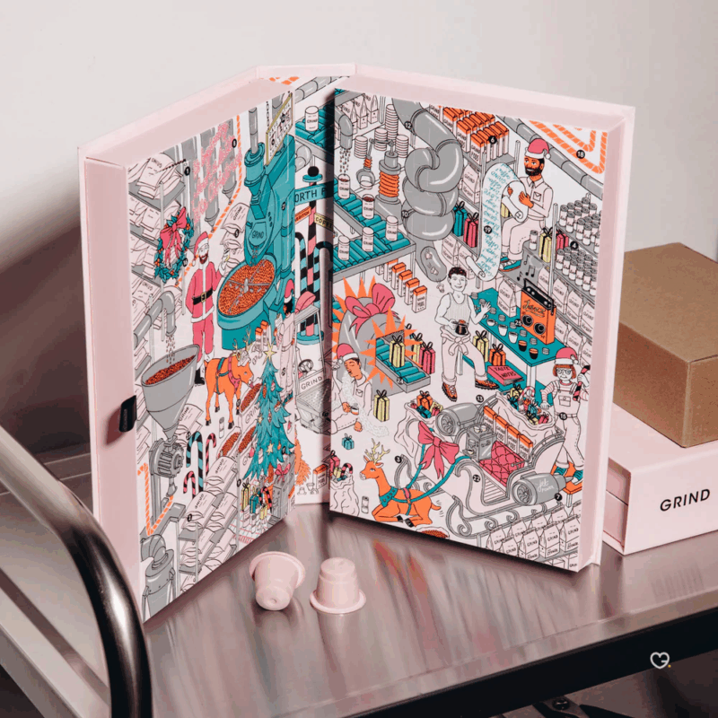 Grind Advent Calendar 2025 : 25 days of exceptional coffee in a pale pink box adorned with a festive street illustration. Enjoy your holiday season, one cup at a time.