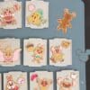Close-up of cloisonne enamel pins from the Disney Pin Advent Calendar 2026, styled as iced Christmas biscuits