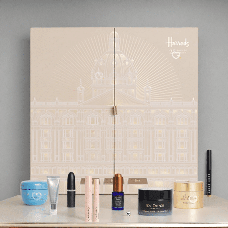 2025 Harrods beauty advent calendar is in a deep forest green casing with beautiful snowy white illustrations. The calendar has 25 drawers each filled with a beauty surprise.