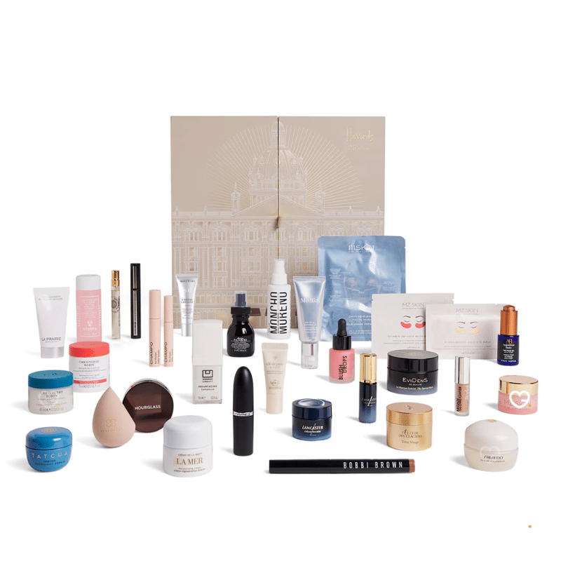 2025 Harrods beauty advent calendar is in a deep forest green casing with beautiful snowy white illustrations. The calendar has 25 drawers each filled with a beauty surprise.