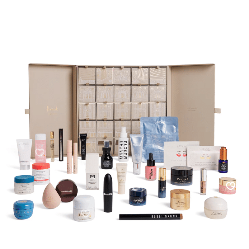 2025 Harrods beauty advent calendar is in a deep forest green casing with beautiful snowy white illustrations. The calendar has 25 drawers each filled with a beauty surprise.