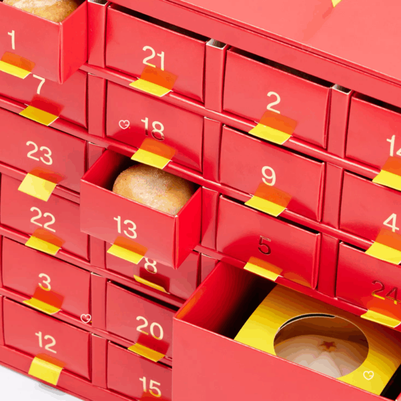 Selfridges Mini Mince Pie Advent Calendar 2025 contains 420g of festive mini mince pies, in a beautifully illustrated festive box, with a handy yellow ribbon for easy carrying