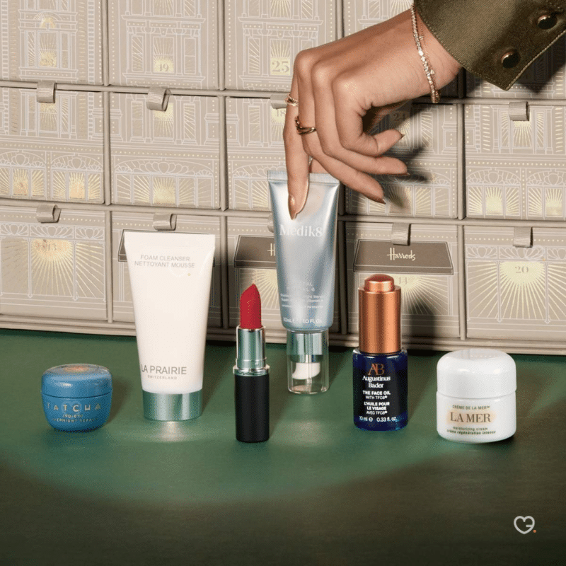 2025 Harrods beauty advent calendar is in a deep forest green casing with beautiful snowy white illustrations. The calendar has 25 drawers each filled with a beauty surprise.