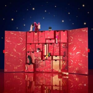 Carolina Herrera Advent Calendar 2026 open box hero shot with fragrances and make-up on a starry background