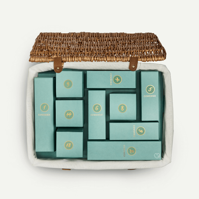 Cowshed Advent Calendar 2025 in a wicker hamper with 24 beauty treats from candles to lotions for festive self-care.