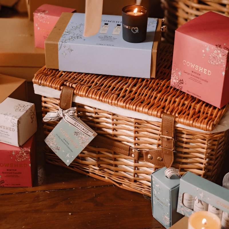 Cowshed Advent Calendar 2025 in a wicker hamper with 24 beauty treats from candles to lotions for festive self-care.