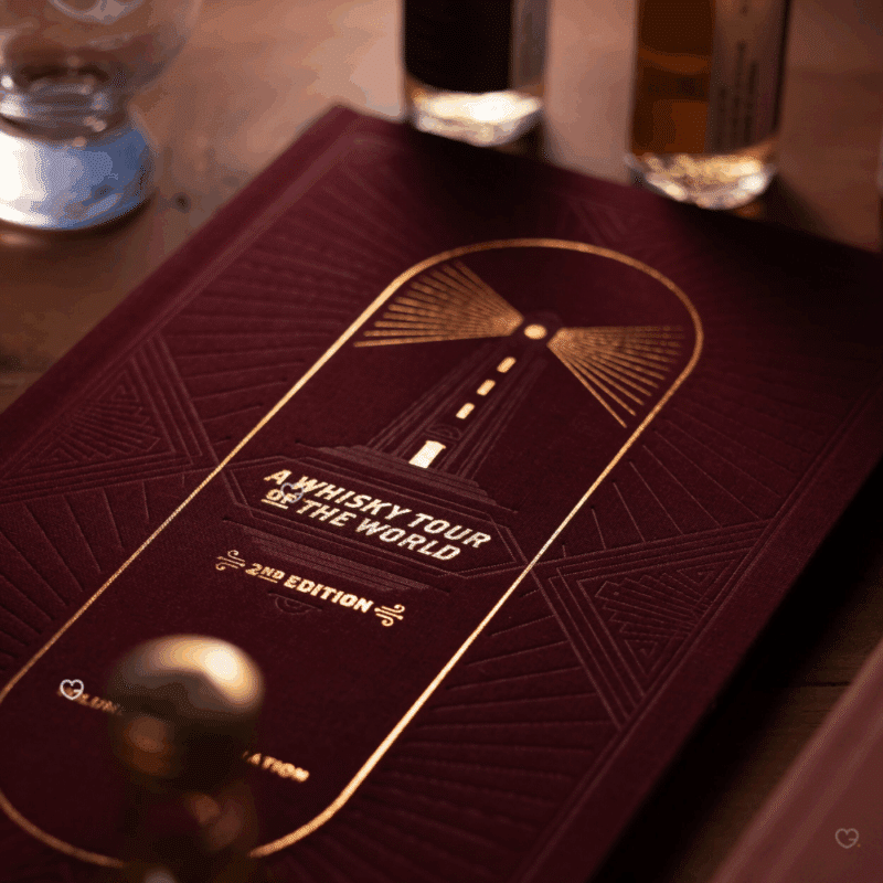 Whisky Tour of Scotland Advent Calendar 2025 is a masterfully designed set, featuring five linen-bound and gold-foiled books within a handmade, engraved wooden bookcase.