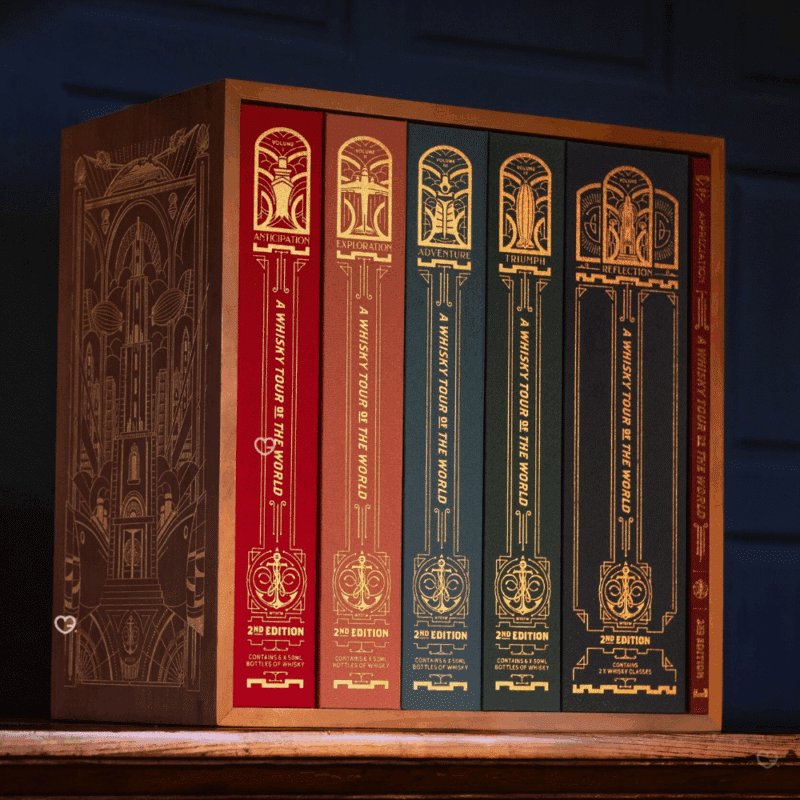 Whisky Tour of Scotland Advent Calendar 2025 is a masterfully designed set, featuring five linen-bound and gold-foiled books within a handmade, engraved wooden bookcase.