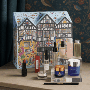 Luxurious Liberty London Beauty Advent Calendar 2025, illustrated in the shape of the iconic Tudor storefront, featuring high-end skincare, makeup, and fragrance products from brands like Le Labo, Augustinus Bader, and Sisley.
