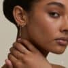 Model wearing gold earrings and rings from the Astrid & Miyu 2026 advent calendar