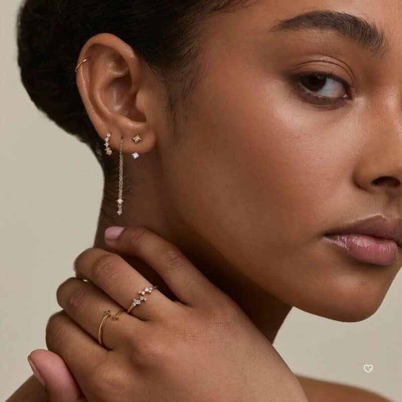 Model wearing gold earrings and rings from the Astrid & Miyu 2026 advent calendar