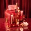 Charlotte Tilbury Advent Calendar 2026 with open jewel-handled drawers, the Pillow Talk charm bag and beauty products on a red backdrop