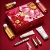 Clarins Advent Calendar 2026 with Tonic body oil, cleanser and make-up on red
