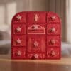 Charlotte Tilbury Advent Calendar 2026, red 12-door beauty chest on a wooden table