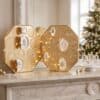 Swarovski Advent Calendar 2026 crystal advent calendar styled beside a lit Christmas tree, opened with crystal candles, the Kris Bear and ornaments displayed in front