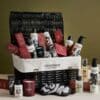 Cowshed Advent Calendar 2026 wicker hamper styled with products and eye mask on olive green