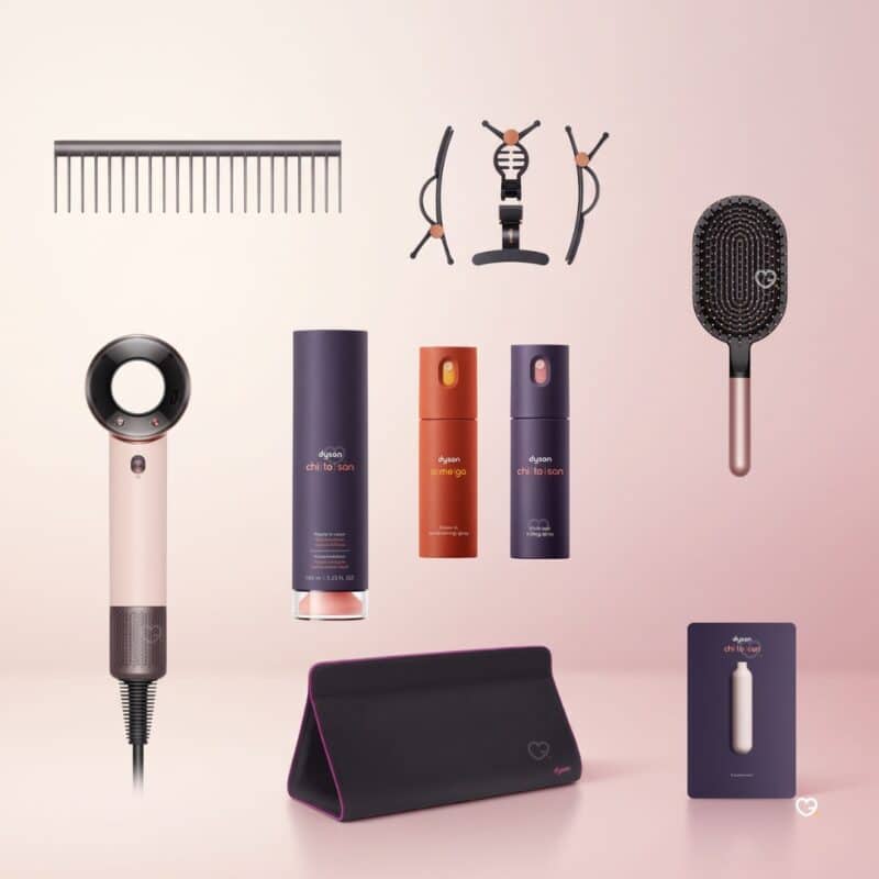 Dyson Advent Calendar 2026 contents spoiler flat lay: comb, hair clips, Supersonic Travel dryer, sprays, paddle brush, storage bag and Pre-Style Cream samples