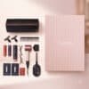 Dyson Advent Calendar 2026 full contents flat lay: storage bag, hair clips, comb, Chitosan and Omega sprays, Supersonic Travel dryer, paddle brush and samples