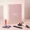 Dyson Advent Calendar 2026 haircare edit with the Supersonic Travel hair dryer, comb, styling spray and samples beside the pink box