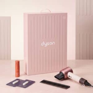 Dyson Advent Calendar 2026 haircare edit with the Supersonic Travel hair dryer, comb, styling spray and samples beside the pink box