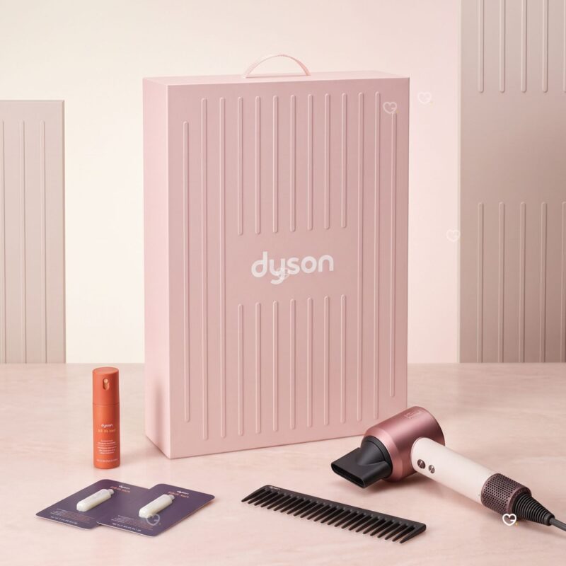 Dyson Advent Calendar 2026 haircare edit with the Supersonic Travel hair dryer, comb, styling spray and samples beside the pink box