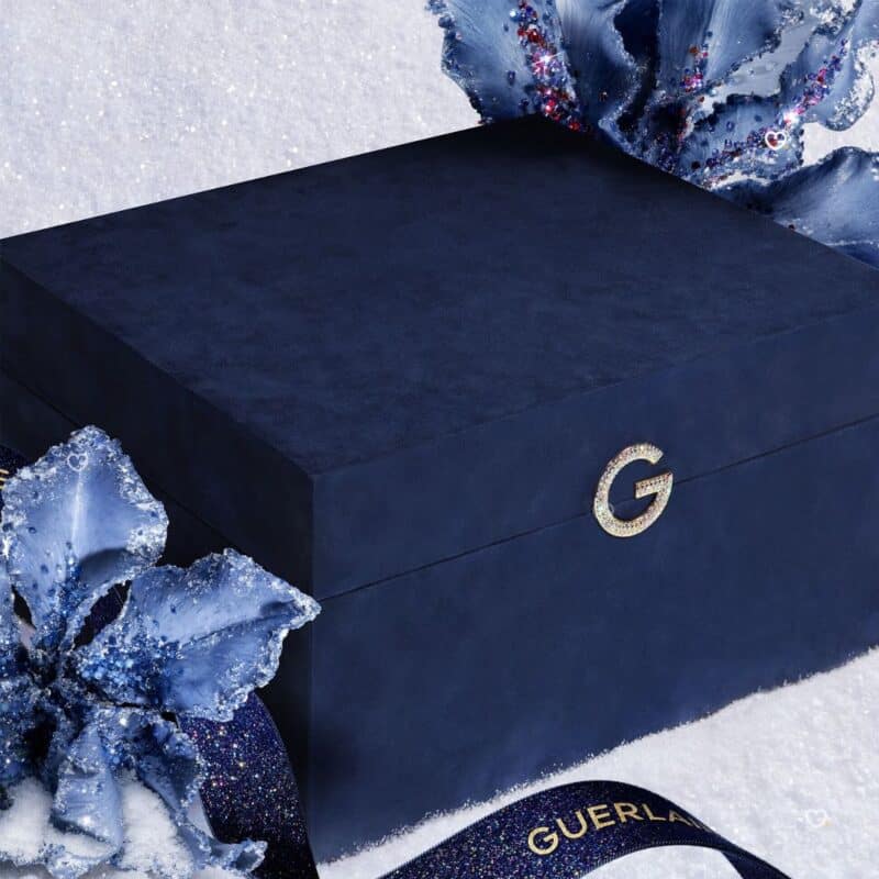 Guerlain Advent Calendar 2026 closed velvet jewellery box in a festive blue floral setting
