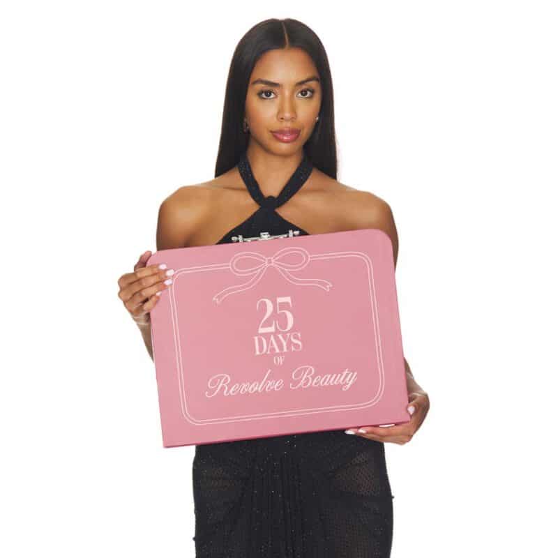 Model holding the pink Revolve Advent Calendar 2026 gift box
