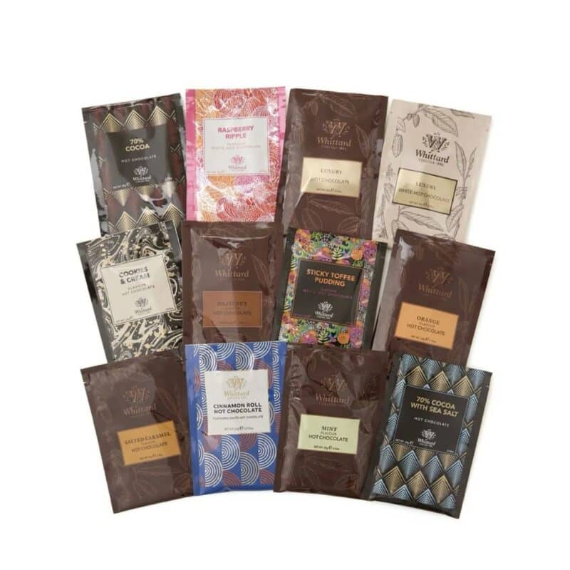 The twelve Whittard hot chocolate flavours from the advent calendar laid out on white
