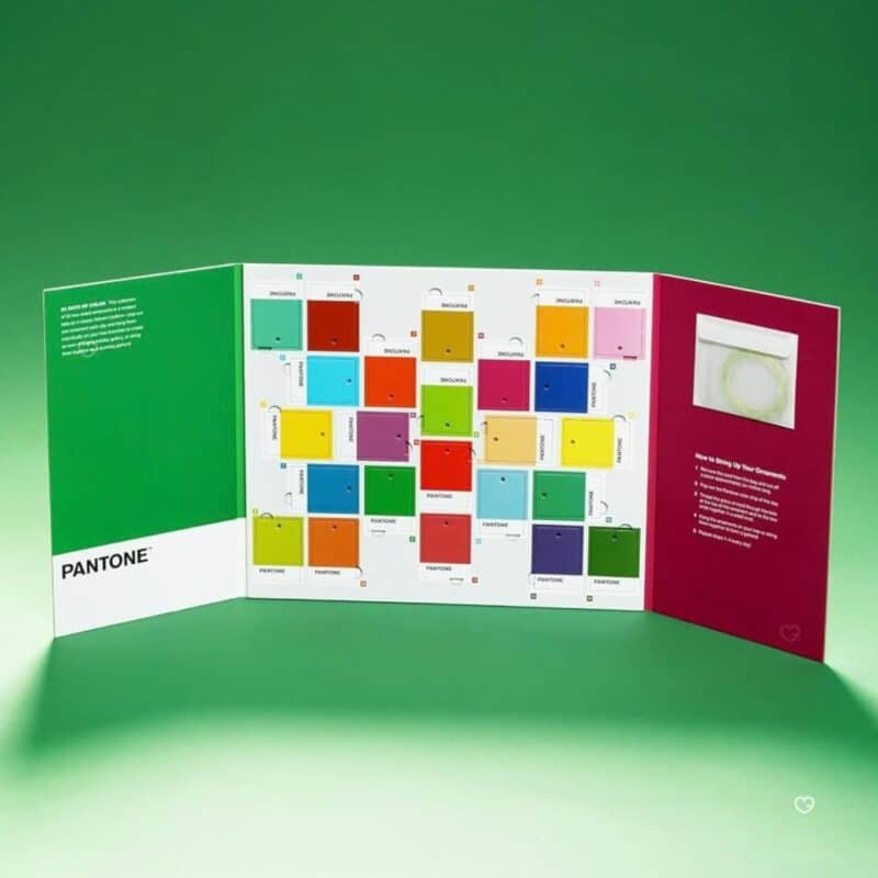 Pantone advent calendar 2026 open three-panel triptych on a green background