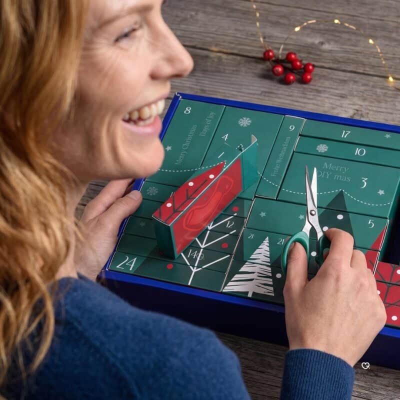 Scanning a Prym Advent Calendar door QR code with a phone to open the step-by-step video tutorial
