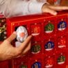 A hand opening a door of the Tenga Advent Calendar 2026, a Tenga Egg in hand