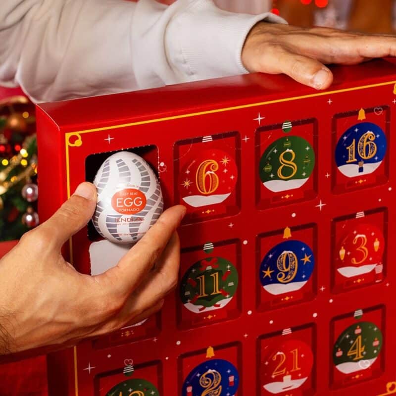 A hand opening a door of the Tenga Advent Calendar 2026, a Tenga Egg in hand