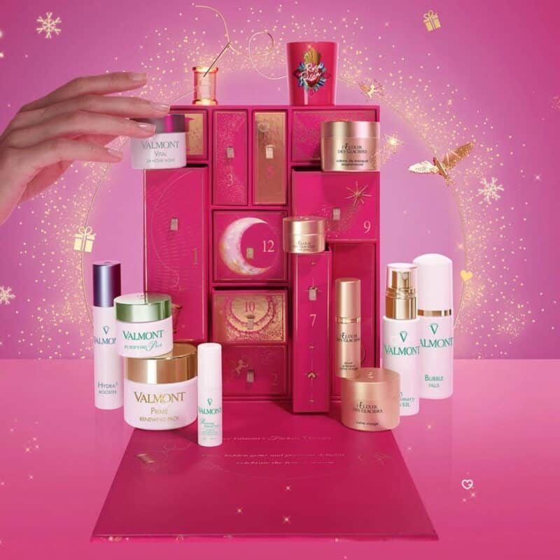 A hand opening a door on the Valmont Advent Calendar 2026 Fuchsia Odyssey